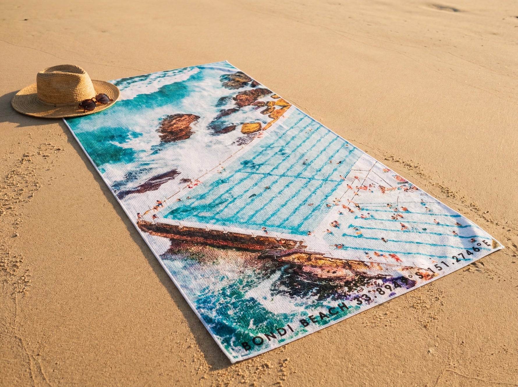 Icebergs Summer Australian beach towel on golden sand showing an aerial photograph of the Bondi Icebergs ocean pool