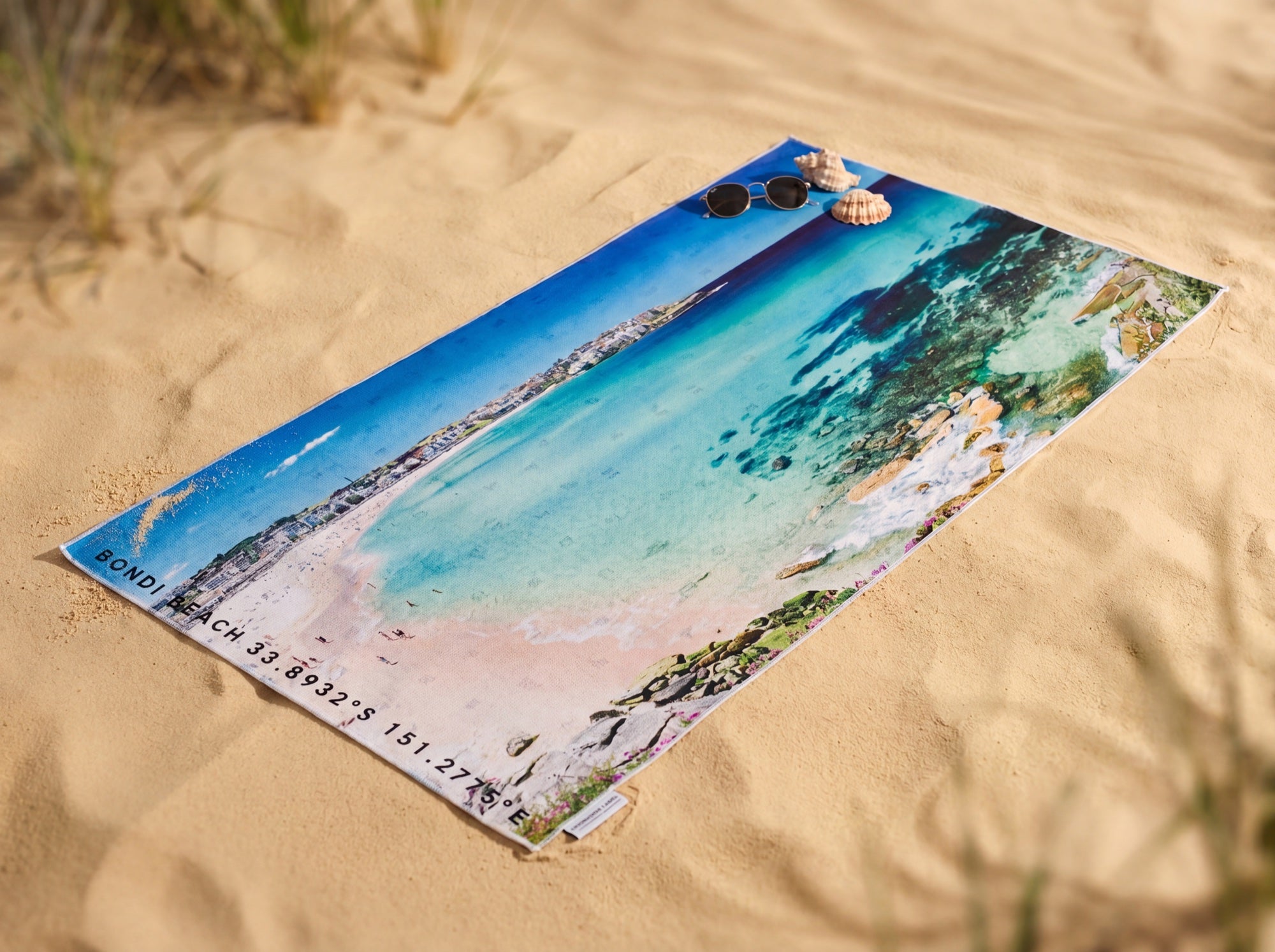 Bondi Blues Australian beach towel on the sand, an aerial photograph of Bondi Beach and its turquoise water